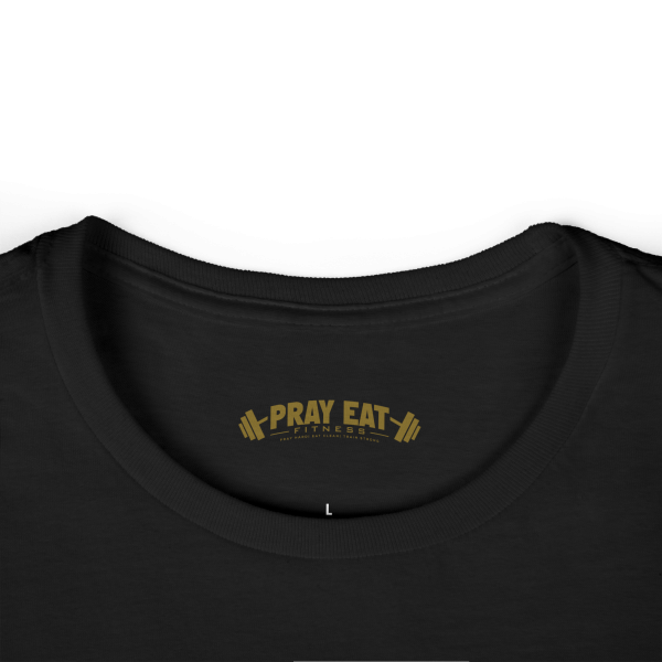 Women's black Christian fitness t-shirt featuring a female weightlifter graphic with the slogan "Pray. Eat. Lift." and "Powered by Purpose."